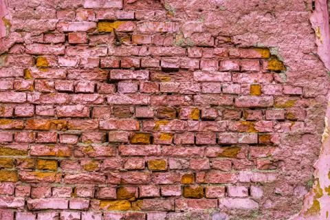 A horizontal texture of part of a old crashed brick wall in pink hue is on the Stock-Fotos