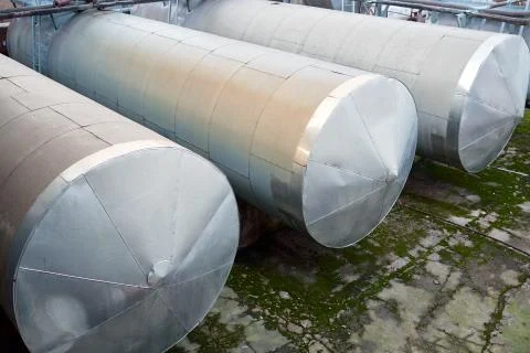 Horizontal three storage tanks storage barrels of chemical plant surrounded b Foto stock