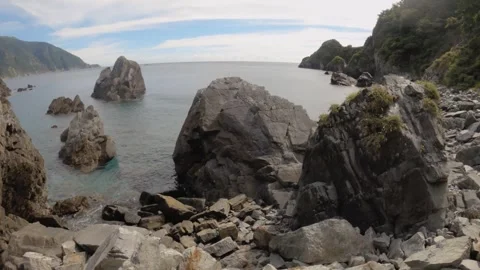 Horizontal tilt up pan view look out to pacific ocean horizon from rocky seashor Stock Footage 263020143