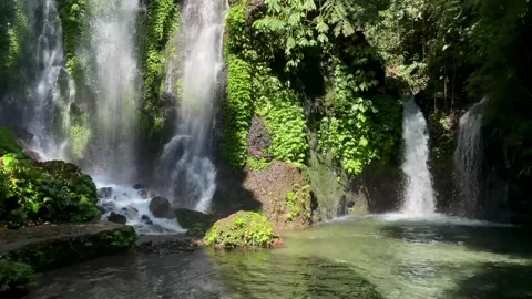 Horizontal Tilt Up Shot of Pristine Waterfall and Clear Pond in Bali Stock Footage 339449473