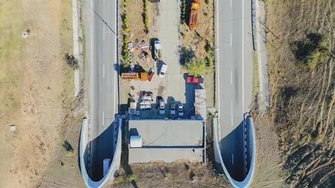 Horizontal top down aerial view of a dual highway entering twin mountain tu.. Foto stock