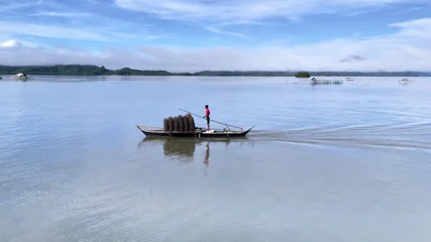 Horizontal tracking drone shot of a local fisherman standing on a moving Stock-Footage 332212580