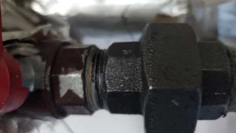 Horizontal tracking shot of a copper pipe connection with a large black nut and Stock Footage 336484618