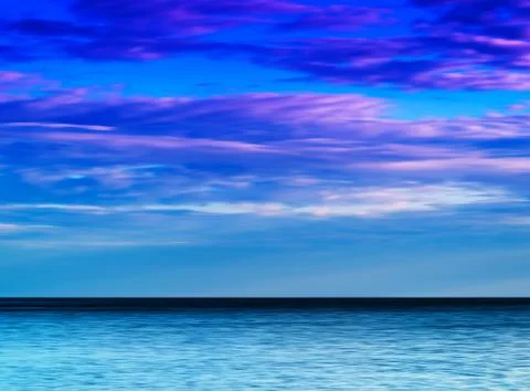 Horizontal vibrant ocean horizon with dramatic cloudscape backgr Stock Photos