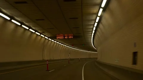 Horizontal video of a car driving through a brightly illuminated road tunnel Stock Footage 342061290