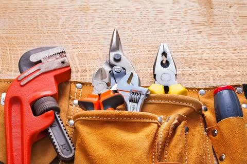Horizontal view building tools in tool belt monkey spanner pliers pliers on Stock Photos