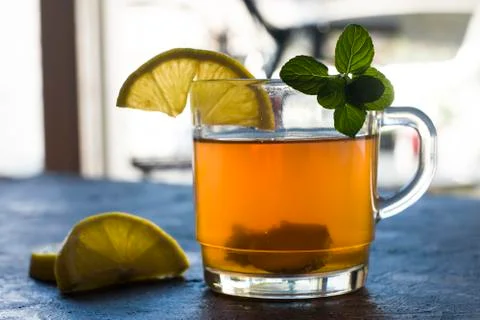 A horizontal view of cup with ginger tea and lemon on a rustic blue table. Stock Photos
