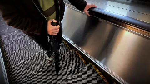 Horizontal View of Escalator Moving Up with Anonymous Man Standing 動画素材 310001643