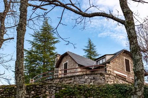 Horizontal view of a house in the middle of a forest surrounded by trees. Fra Stock Photos