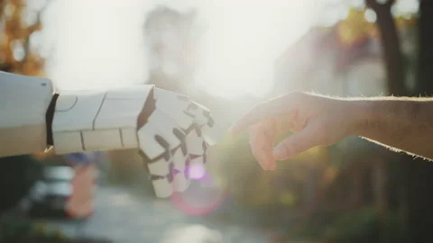 Horizontal view of male hand and robot hand on blurred background of park in Stock Footage 232873151