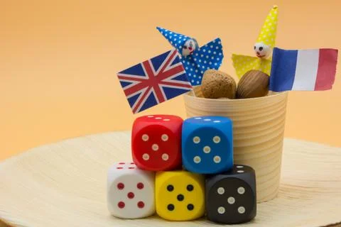 Horizontal View of Peanuts, Five Colored Dices and the France and Great Brita Фото