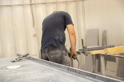 Horizontal view of a professionally dressed carpenter varnishing a board Foto stock