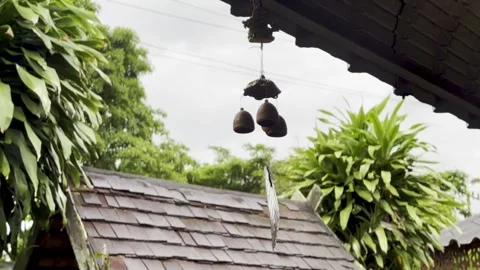 Horizontal View of Rustic Metal Wind Chime and Traditional Roof Stock Footage 339119072