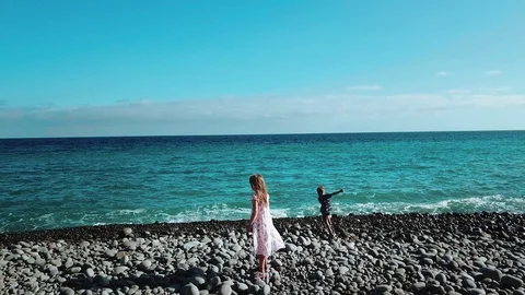 Horizontal view on the turquoise ocean and blue sky during summer time. Two kids Stock Footage 95896801