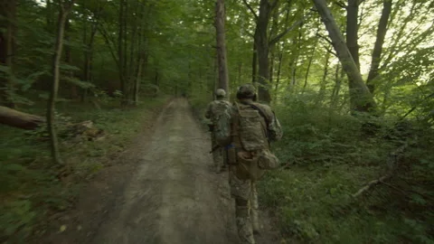 Horizontal view of two soldiers in uniform holding weapons in hands. One Stock Footage 241001090