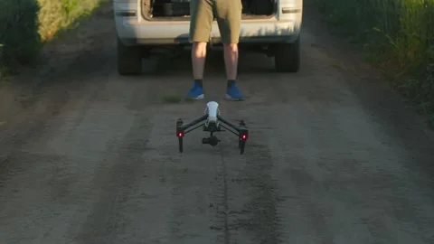 Horizontal view of unrecognized young man standing near car and launching drone Stock Footage 201462671