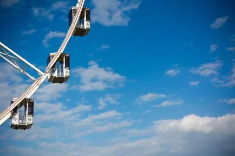 Horizontal View of a White Ferris Wheel on Partially Cloudy Sky Background. C Stock Photos