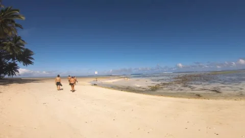 Horizontal walking along beach side view of Avaavaroa with golden sand and blue  Stock Footage 250470070