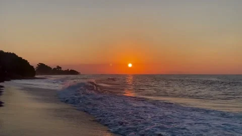 Horizontal wide shot of cinematic sunset beach with rolling ocean waves Stock Footage 336494289