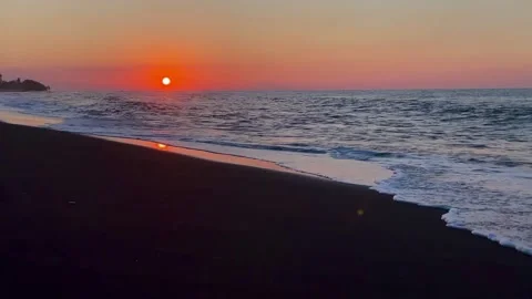 Horizontal wide shot of deep sunset on Bali black sand beach Stock Footage 336494287