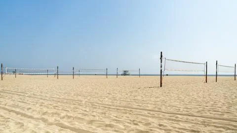Horizontal wide shot of empty beach volleyball nets set up on the wide sand.. Stock Photos