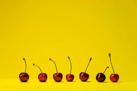 Horizontal yellow summer background with red ripe cherries. Stock Photos