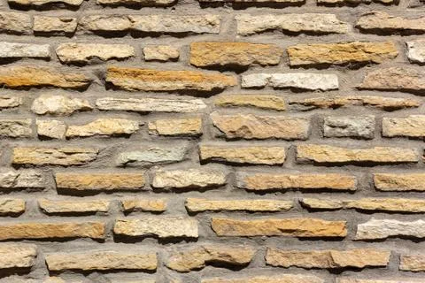 Horizontally aligned limestone wall stone blocks. Colorful texture of the Stock Photos
