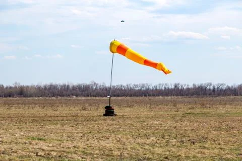 Horizontally flying windsock wind vane with red and yellow lines Foto stock