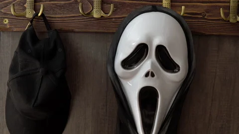 The horrible scream mask hangs on a hook along with the headdress. A maniac in a Stock Footage 163779208