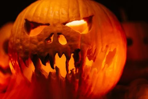 Horrible steaming pumpkin as head of jack-o-lantern with carved eyes and wicked Stock Photos