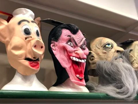 Horrifying carnival mask close-up in store. Vampire, pig and zombie masks.  Stock Photos