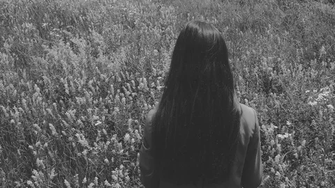 Horror atmosphere with one long haired woman in wildflowers field. Stock Footage 77190769