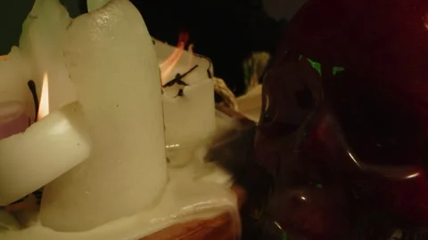 Horror concept: Dolly from a blood filled glass skull to burning candles at an Stock Footage 336004302
