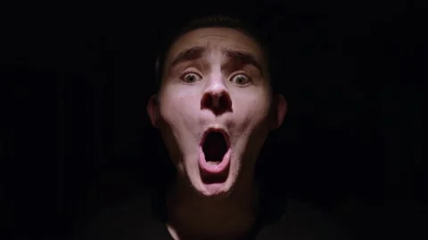 Horror esque model makes freaky face in dark hard lit setting Stock Footage 143069600