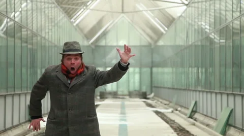 Horror expression of man with the hat, coat and red scarf in a glass room Stock Footage 47931880