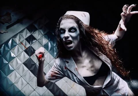 Horror shot: terrible evil crazy nurse (doctor) attacking by bloody syringe.  Stock Photos