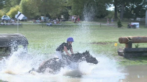 Horse and rider stumbles at water jump Stock Footage