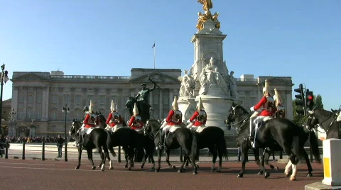 Horse guards soldiers pass the Victoria Memorial at Buckingham Palace London Stock Footage