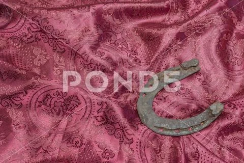 Horse shoe on a red textile background Stock Photos