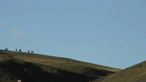 Horsemen riding on a hillside Stock Footage 72772041
