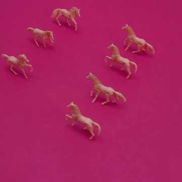 Horses lined up in two rows with a slight shadow on a pink background. Mini.. Foto stock