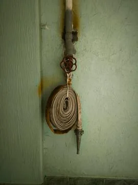 A hose is hanging from a wall.  Stock Photos