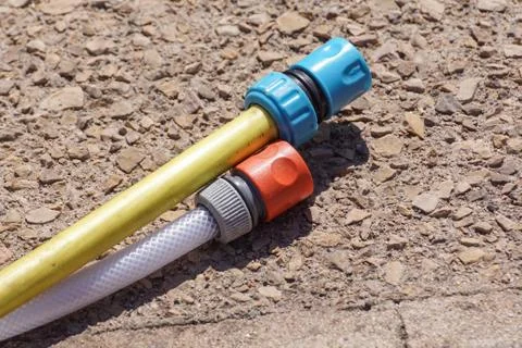 Hose pipe and coupling on ground - selective focus on the front Stock Photos