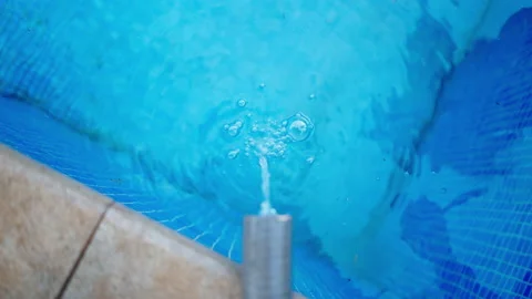 Hosepipe pouring water into clean pool - above shot Video stock 209548645