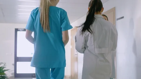 In the Hospital, Back View Shot of Nurse and Doctor Walking Through Hallway.  Stock Footage