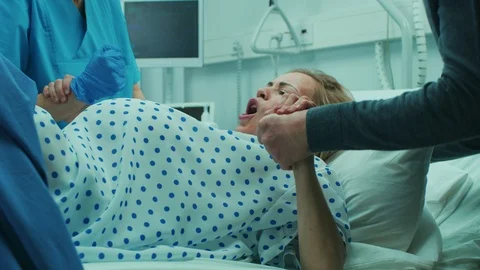 In the Hospital, Close-up on a Woman in Labor Pushing Hard to Give Birth. Stock Footage