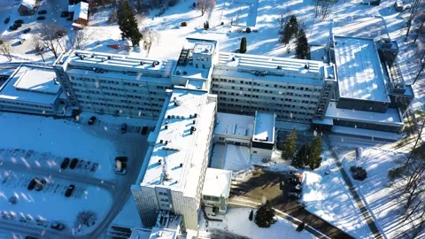 Hospital complex covered in snow, showcasing medical business facility in Видео 333115510