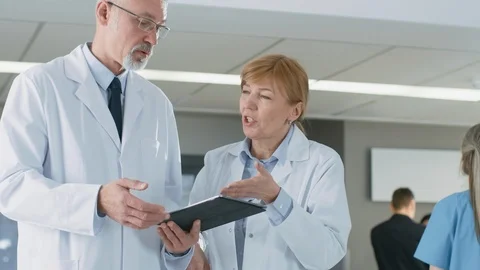 In the Hospital Doctors have Discussion while Using Tablet Computer Video stock 90171734