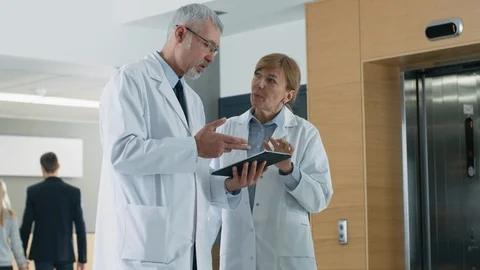 In the Hospital Doctors have Discussion while Using Tablet Computer. Vídeos de archivo 90333407