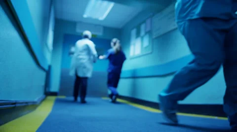 Hospital emergency team rush a patient on a gurney to the operating theatre Stock Footage